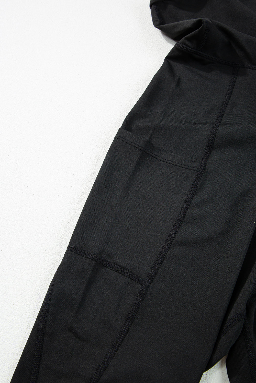 Combinaison de sport noire taille haute, dos nu, poches latérales