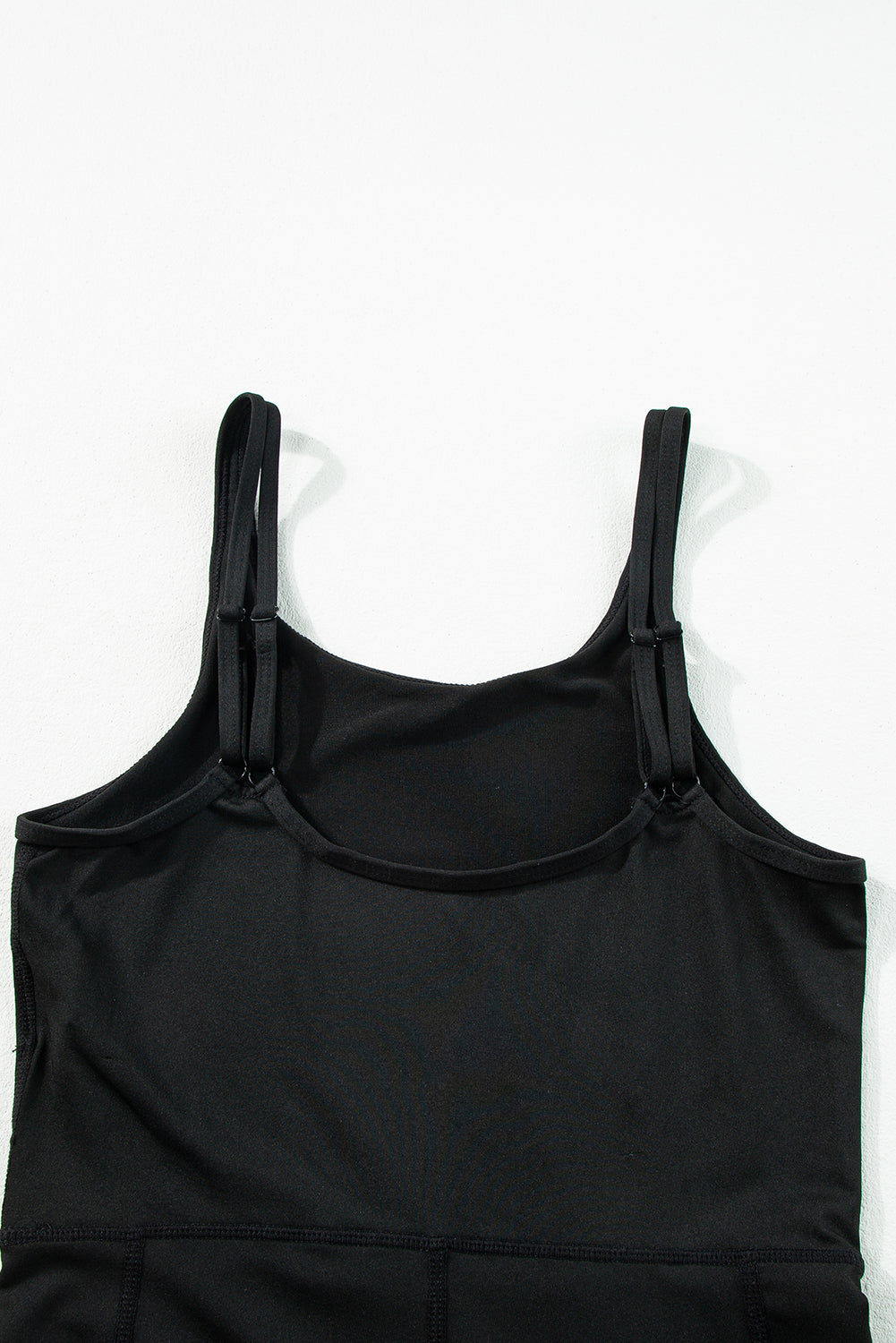 Combinaison de sport noire taille haute, dos nu, poches latérales