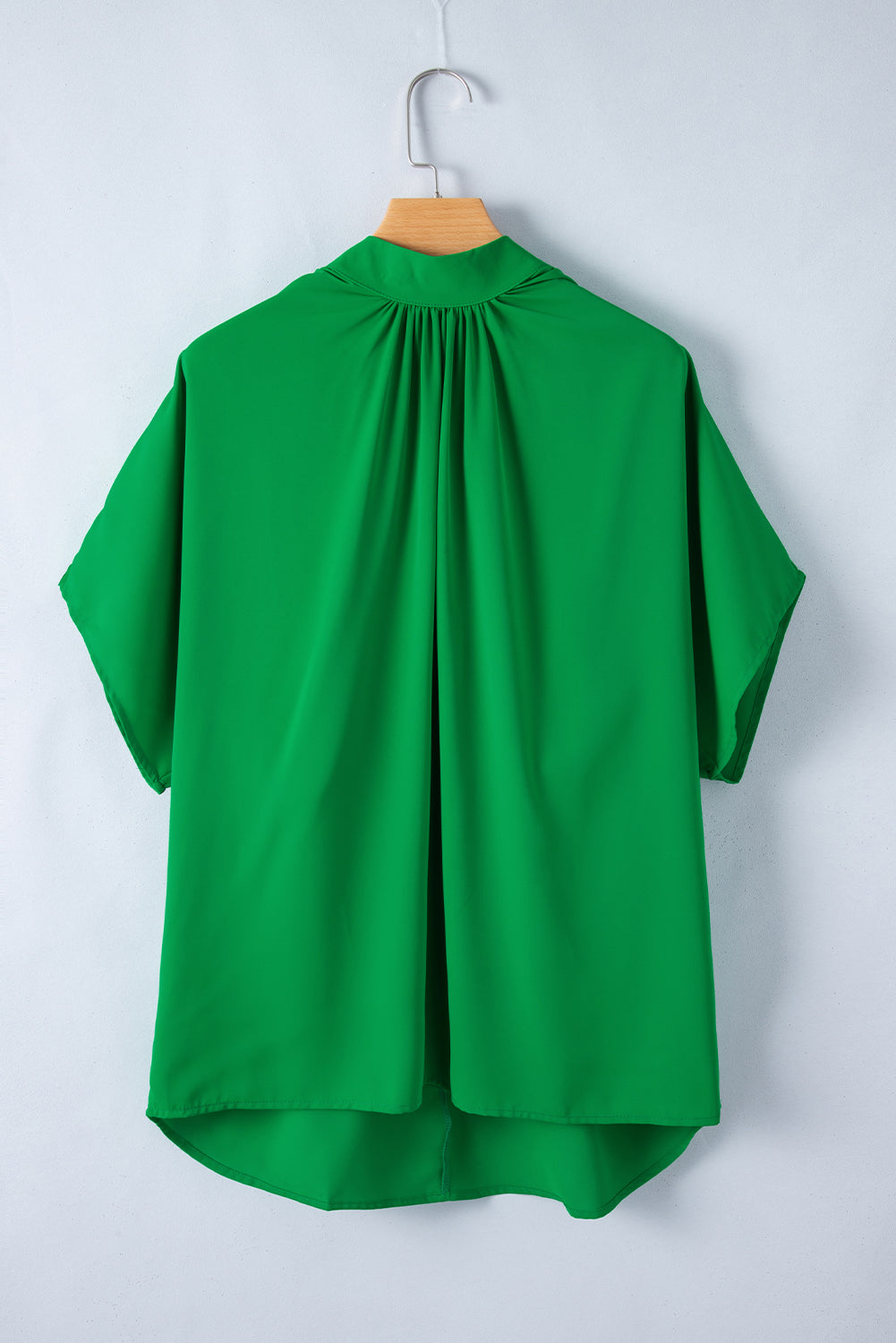 Blusa verde brilhante com gola simulada e manga morcego dividida