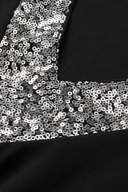 Blouse noire à manches flottantes et col en V à sequins contrastés