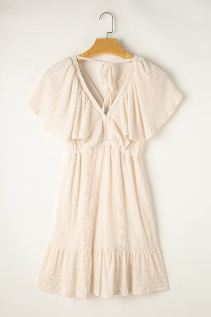 Mini-robe texturée beige à col en V profond et dos découpé