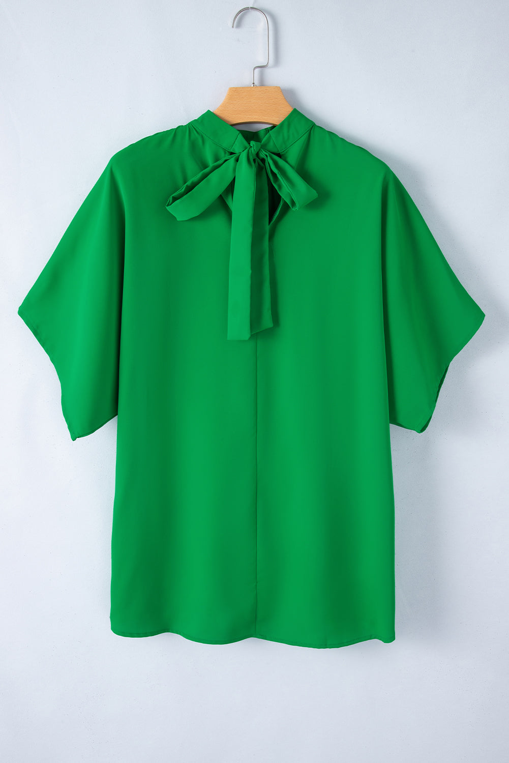 Blusa verde brilhante com gola simulada e manga morcego dividida