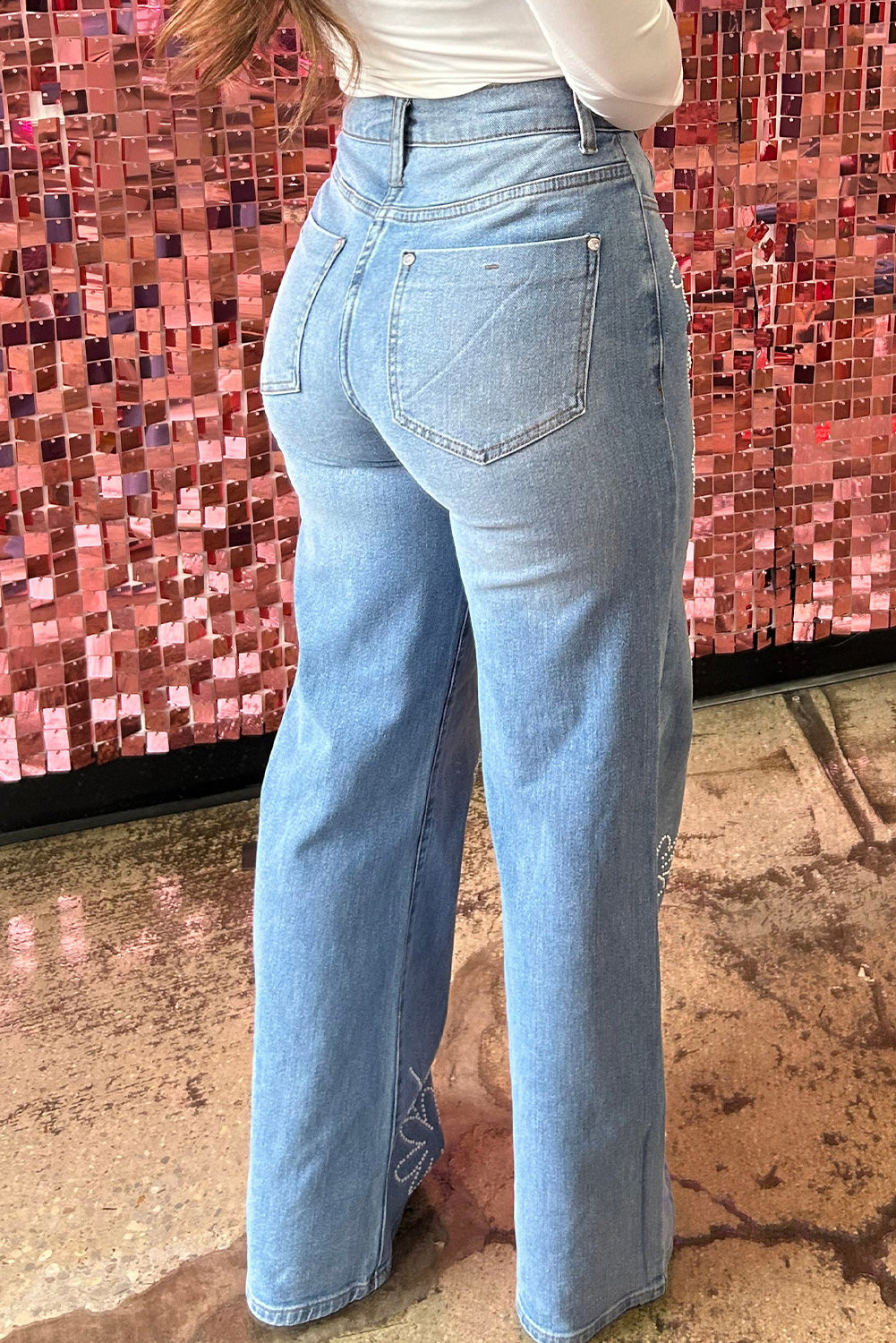 Jeans de perna larga com decoração floral azul claro com strass e cintura alta